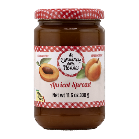 Jar of apricot spread with a red and white checkered lid on a white background