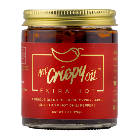 Jar of 'Hot Crispy Oil' Extra Hot with red label and gold lid on white background