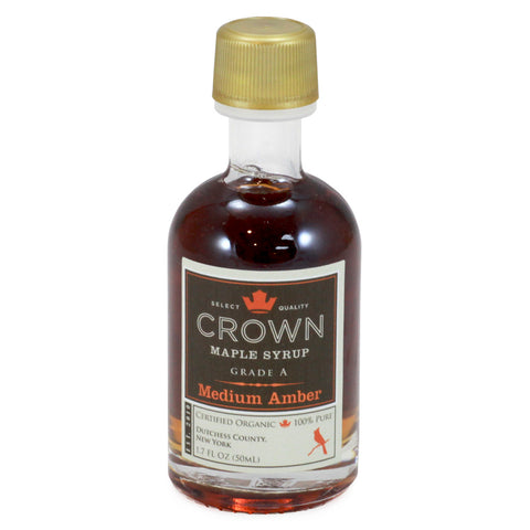 Bottle of Crown Maple Syrup with a gold cap on a white background
