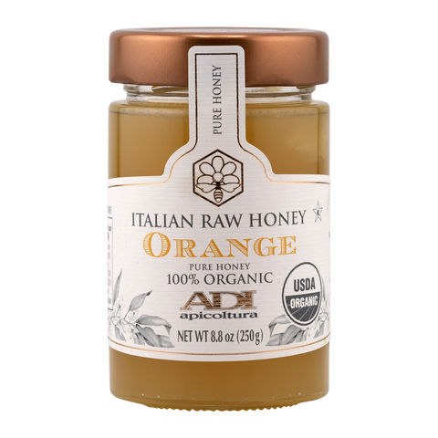 Jar of Italian raw honey with a white label on a white background