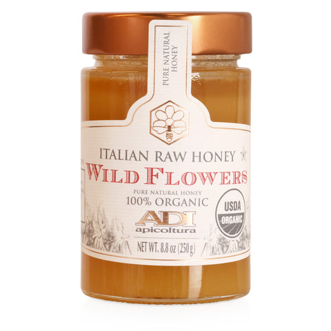Jar of Italian raw honey labeled 'Wild Flowers' with a visible brand logo on a white background.