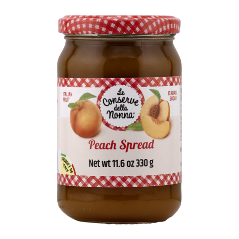 Jar of peach spread with a red and white checkered lid on a white background