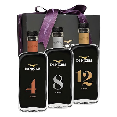 Three bottles of De Nigris with different ages displayed in front of a branded box.